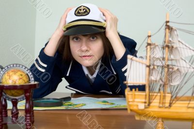 Scared girl in sea uniform at a table