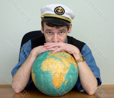 Man in uniform cap with globe Man in uniform cap with globe