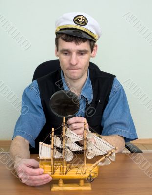 Guy in a sea cap with toy sailing vessel