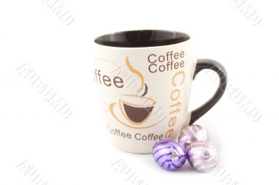 cup with text coffee with some chocolate eastern eggs next to it