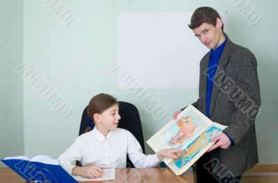 Tutor and schoolgirl with atlas