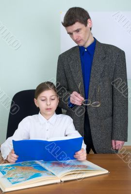 Tutor and schoolgirl with book and atlas