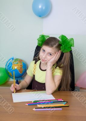 Girl sitting at a table with pencils