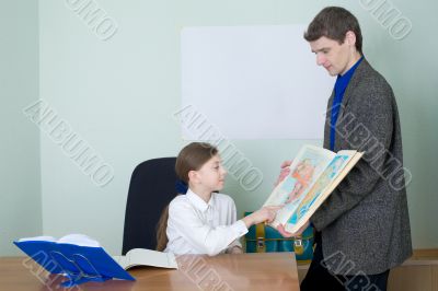 Tutor and schoolgirl with atlas