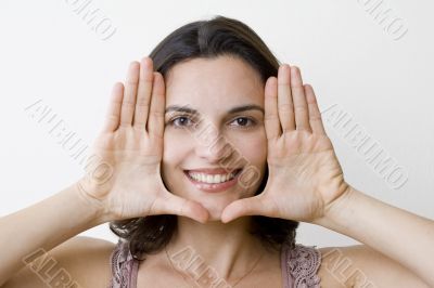 Young woman frame her face with palms