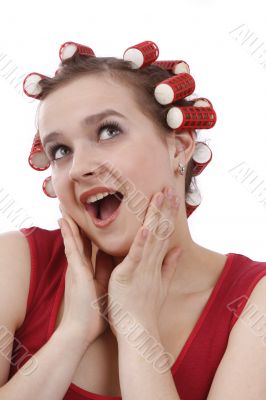 Woman with curlers in her hair looking surprised.