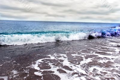 Sea wave and cloudy sky