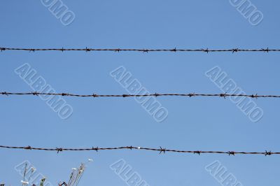 Three rusty strands of barbed wire