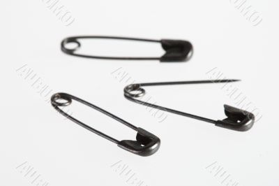 Safety pins on white background