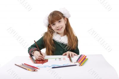 Schoolgirl is  drawing  in pencil.