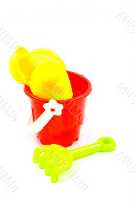 Red bucket and toys, isolated on white background