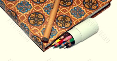 Normal pencil, tiny pencils and notebook