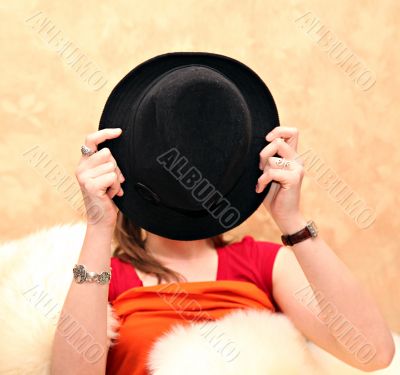 Young girl covering her face with a hat