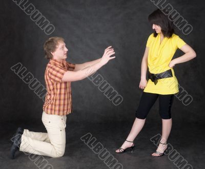 Man is kneeling to the young woman