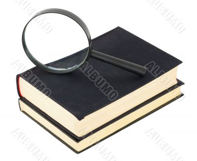 Two black books and magnifier glass on white Two black books and magnifier glass on white