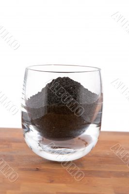 black onion seeds in glass on wooden table