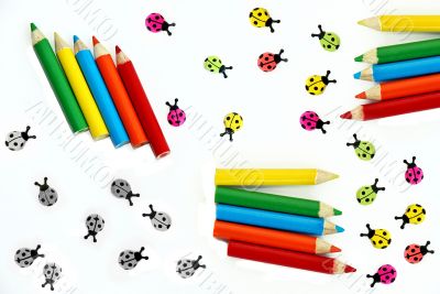 Multicolored crayons and ladybirds composition