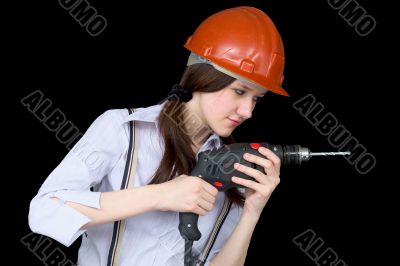 Young woman in a protective helmet with a drill