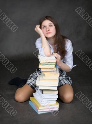Girl sits having leant the elbows on a books Girl sits having leant the elbows on a books