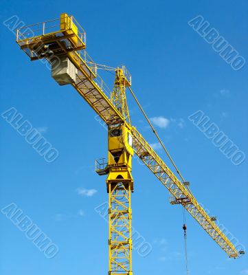 yellow building crane over blue sky background