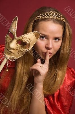 beautiful girl with carnival mask shows gesture of silence