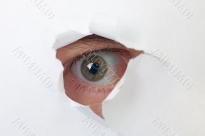 Human eye looking through a hole in paper Human eye looking through a hole in paper