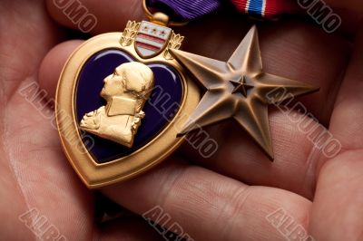 Man Holding Purple Heart and Bronze War Medals