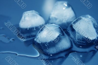 colored ice cubes melted in water on reflection