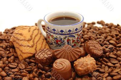 Cup of coffee with cookies and chocolates