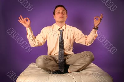 Young businessman meditating on sofa Young businessman meditating on sofa