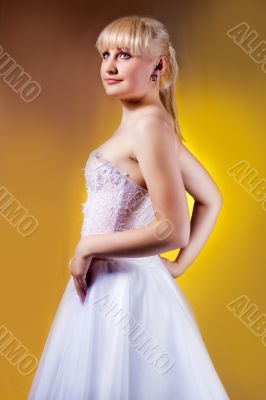 young blonde in wedding dress turned back