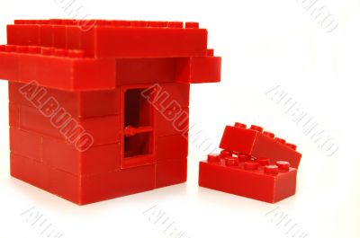 Small house constructed of red toy blocks