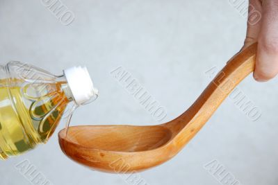 Pouring oil in wooden spoon