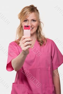 Female nurse holding up cell phone