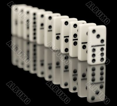 Some bones of dominoes put abreast on a black