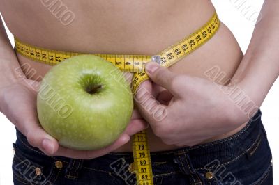Waist is 65.5. Woman with measure tape and apple