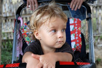 The thoughtful little girl in a carriage