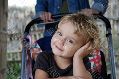 The thoughtful little girl in a carriage