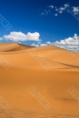 sand dunes and cumulus clouds