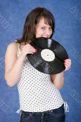 Girl biting a phonograph record on a blue