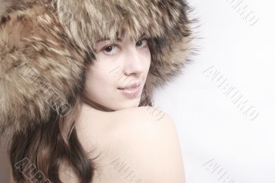 Portrait of the beautiful girl in a fur cap .