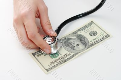 Doctor holding stethoscope at 100 usd banknote