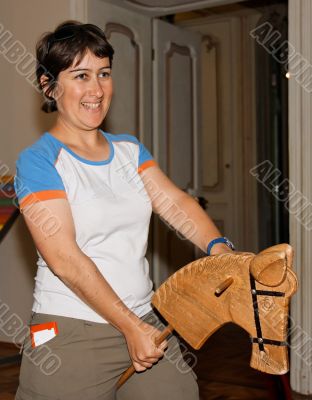 Smiling woman riding a hobby-horse