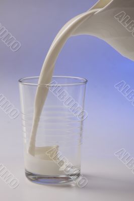 milk pouring in glass from pitcher