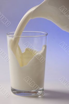 milk pouring in glass from pitcher