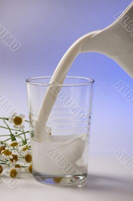 milk pouring in glass from pitcher