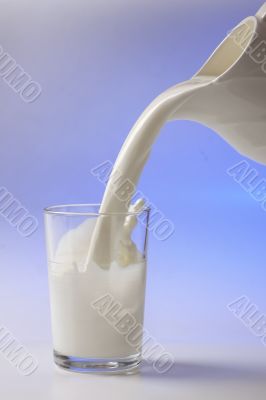 milk pouring in glass from pitcher