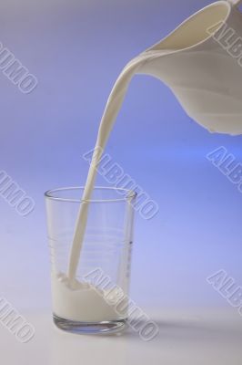 milk pouring in glass from pitcher