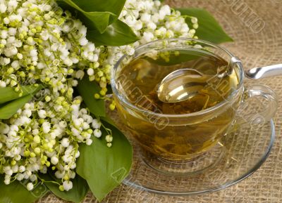 cup of green tea on hessian with honey spoon