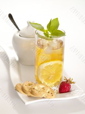 Cold black tea  with lemon, ice and water drops on the glass sur